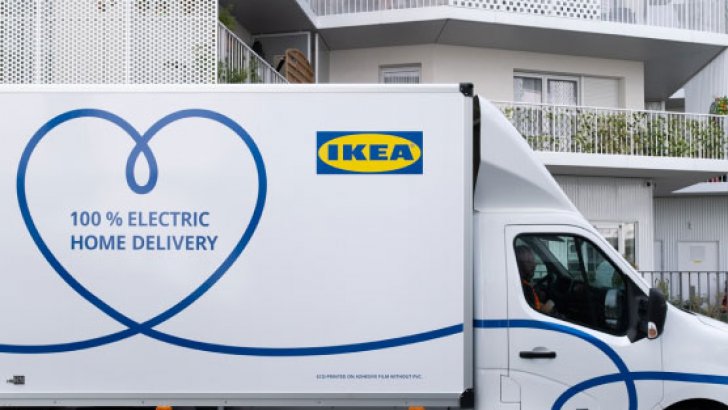 An IKEA home delivery truck parked in front of a white building
