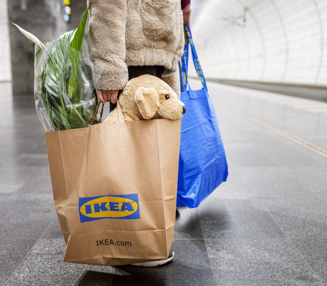 Person holding IKEA bags waiting for the train home after shopping in an IKEA store
