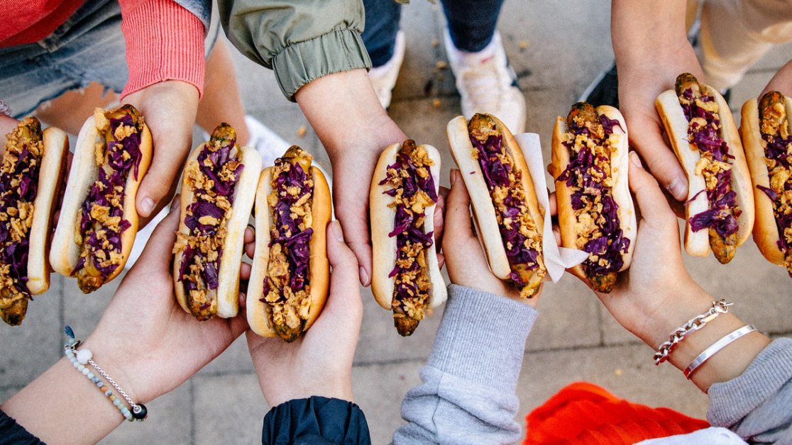 A group of friends holding veggie hotdogs.