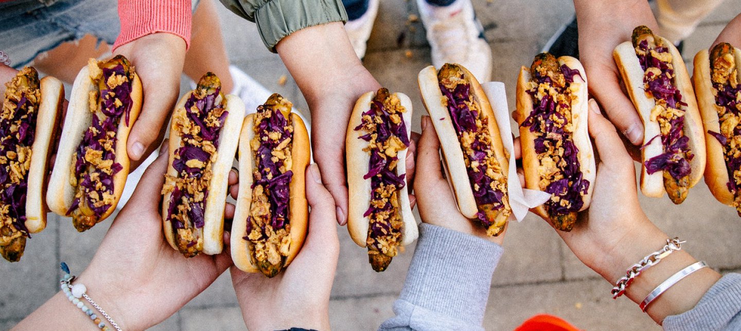 A group of friends holding veggie hotdogs.