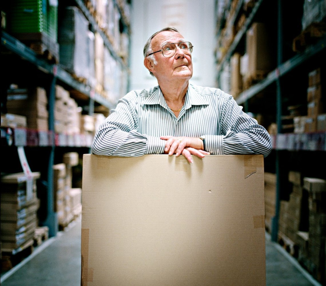 Ingvar Kamprad standing in the IKEA store ware-house with a cardboard box.