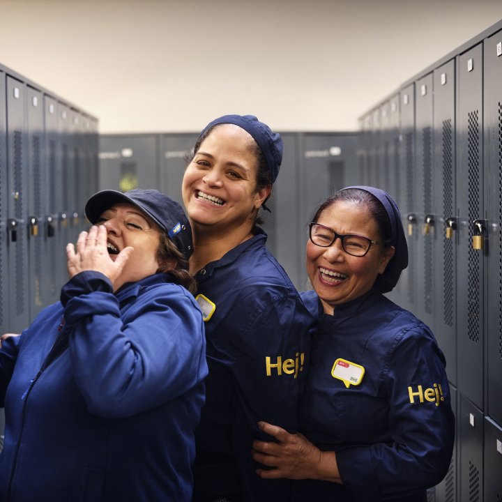 Three IKEA employees laughing together in a locker room.